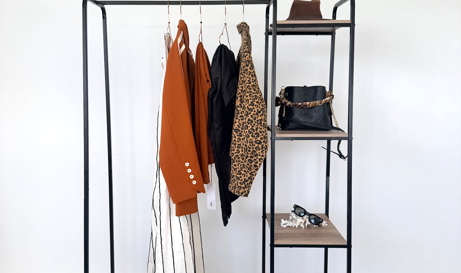 Capsule wardrobe clothing pieces on a minimalist rack