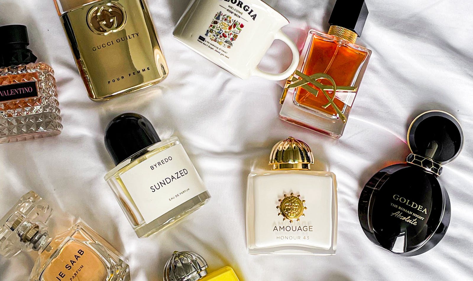 Perfume bottles and fragrance notes styled on a neutral surface